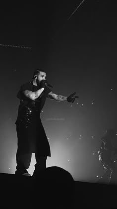 a man standing on top of a stage with his arms out in front of him