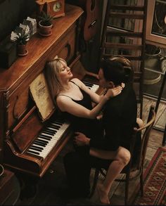 two people sitting next to each other at a piano