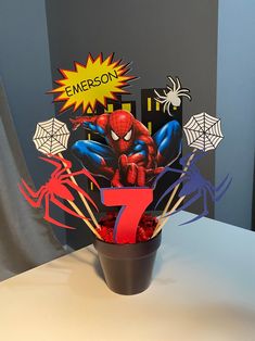 a spiderman centerpiece in a flower pot with the number seven on it's side