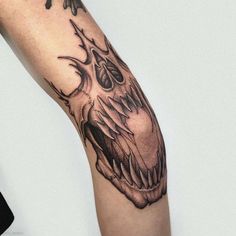 a person with a tattoo on their arm holding a cell phone in one hand and a skull in the other