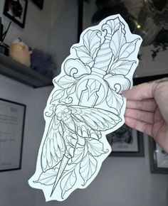 a person holding up a sticker with flowers and leaves on it in their hand