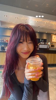 a woman holding a jar filled with liquid