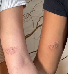 two people with matching tattoos on their legs, one is holding the other's arm