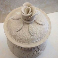 a white vase with a flower on it