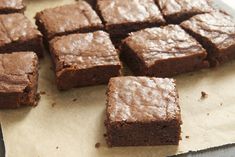 some brownies sitting on top of a piece of parchment paper