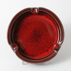 a red bowl sitting on top of a white table