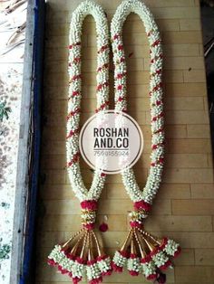 white and red garlands hanging from the side of a wall with a sign that says roshan and co