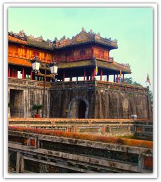 an old chinese building with many windows and arches on the roof, in front of a blue sky