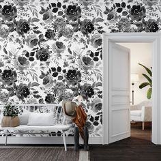 an open door leading to a living room with black and white flowers on the wall