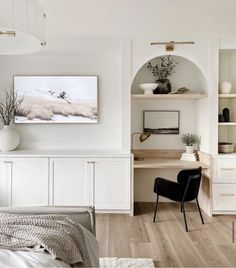 a bedroom with white walls and wooden flooring, built - in shelving units