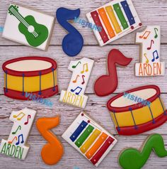 decorated cookies with musical instruments and music notes on top of a wooden table for children's birthday party