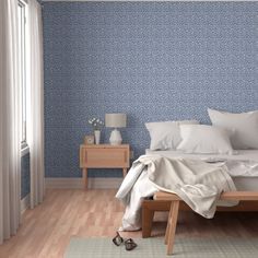 a bedroom with blue wallpaper and white bedding