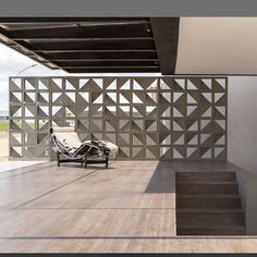 a chair sitting on top of a wooden floor next to a wall covered in geometric designs