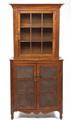 an old wooden cabinet with glass doors and drawers on the front, against a white background