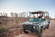 two people riding in the back of a green vehicle