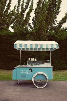 an ice cream cart parked in front of some trees