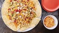 a white plate topped with tortilla shells covered in shredded cheese and toppings