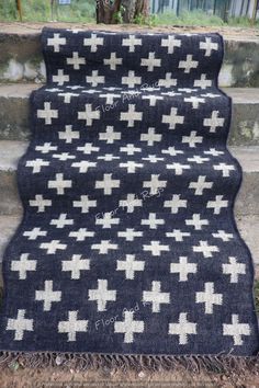 a black and white rug sitting on top of some steps with an open door in the background