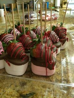 chocolate covered strawberries are arranged in small cups on a table with toothpicks sticking out of them