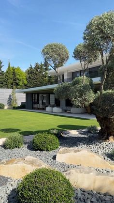 a modern house surrounded by trees and grass