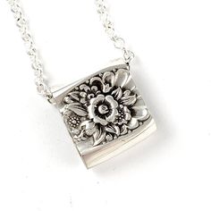 a silver necklace with a flower on it