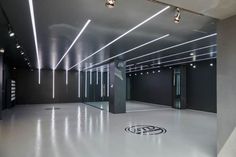 an empty room with several lights on the ceiling and two doors in the center,