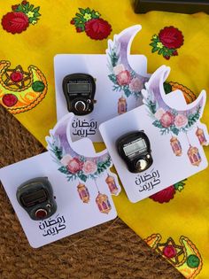 three different types of electronic devices on a yellow cloth with flowers and other items in the background