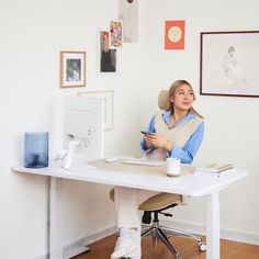 a woman sitting at a desk with a cup in front of her