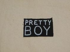 there is a patch that says pretty boy on the back of a shirt with white writing