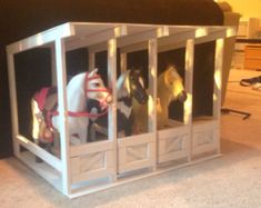 three toy horses are in a small cage