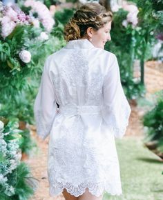 a woman in a white robe walking down a path