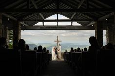 the bride and groom stand at the alter during their wedding ceremony on top of a mountain