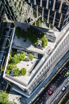 an aerial view of a city with tall buildings and cars driving down the street in front of them