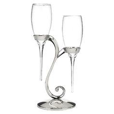 two wine glasses sitting next to each other on top of a silver plated stand