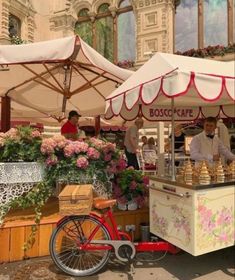 an outdoor food cart with flowers on display