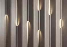 three lights are lit up on the side of a wall in a room with wood paneling