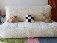 a white couch with four pillows on it