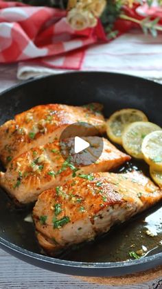 two pieces of fish in a pan with lemon slices