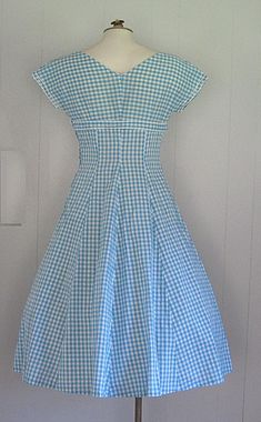 DESCRIPTION 1950s cotton dress Blue and white gingham Wide v-neck embellished with rhinestones and beads Under bust bow Fitted bodice/waist and full skirt Hand made Narrow white rick rack trim APPROXIMATE MEASUREMENTS (INCHES): Bust: 33 Waist: 26 Hip: OPEN Bodice (shoulder to waist): 15 Skirt (waist to hem): 30 CONDITION Excellent/very good. The under arms on both sleeves have been repaired/reinforced. Aside from this, the dress appears unworn. Summer Dress Blue, Dress With Rhinestones, Blue Summer Dresses, Character Sketches, Outfit Design, Vintage Pin Up, Rick Rack, Day Dress, 1950s Vintage