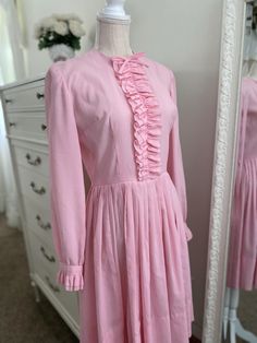 Vintage 70's Pink Bubblegum Ribbon Pleated  Accordion Dress- Shabbychic Spring  Size: Small/Medium Chest: 18.5" pit to pit laying flat Waist: 14.2" (zero stretch)  Length: 37.2" hits right below the knee  *Zero stretch* -This dress can accommodate modern day sizes Small through Medium. -Sinches at waist, accordion pleated skirt -Vertical ruffled feature on chest, complete with ribbon bow at top. -Unlined, skin color undergarments recommended. -Snap clasp wrist closure on each wrist, can be worn 1970s Fitted Vintage Dress For Daywear, Fitted 1970s Vintage Dress For Daywear, 1970s Style Fitted Vintage Dress For Daywear, Mid-century Long Sleeve Fitted Dress, Fitted Mid-century Long Sleeve Dresses, 1970s Long Sleeve Dresses For Spring, 1970s Style Long Sleeve Dresses For Spring, Vintage Long Sleeve Dress For Spring Fashion, Feminine Fitted Vintage Dress