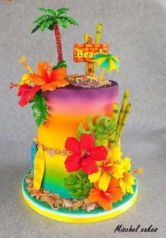 a multi - colored cake decorated with palm trees and flowers