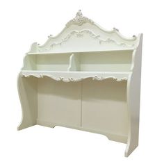 a white wooden shelf with two shelves on it's sides and an ornate design at the top