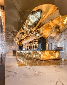 the interior of a modern bar with gold and black decor on the walls, along with marble flooring