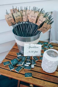 a table topped with lots of wooden sticks and place cards on top of it's holders