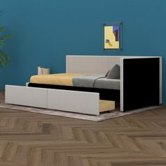 a bed sitting on top of a wooden floor next to a plant