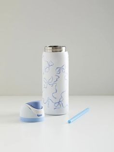 a white and blue water bottle sitting on top of a table next to a toothbrush