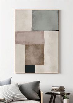 an abstract painting hangs on the wall above a couch in a living room with pillows