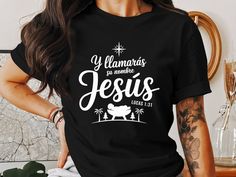 a woman wearing a black t - shirt with the words jesus printed on it