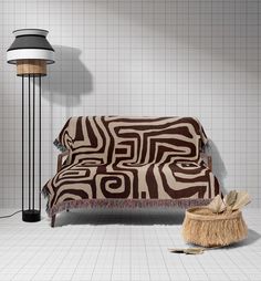 a brown and white couch sitting next to a lamp on top of a tiled floor