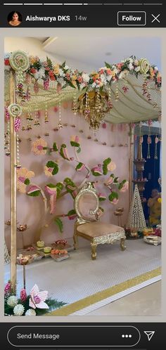 a room decorated in pink and gold with flowers on the wall, chandelier and bench